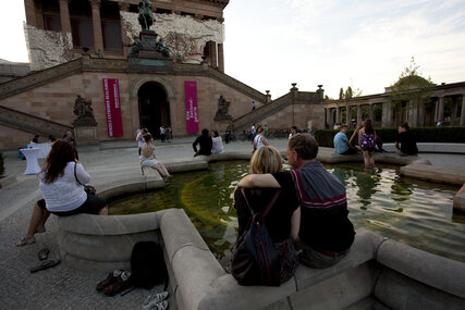 Gente sentada en la fuente frente a la Antigua Galería Nacional