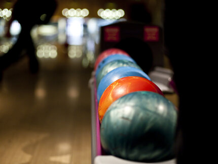 Colorful bowling balls on rack on bowling lane