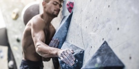 Hombre atlético en una pared de búlder