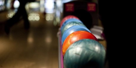 Colorful bowling balls on rack on bowling lane