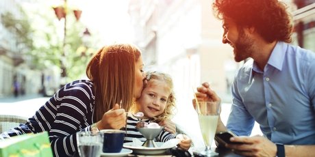 Vater und Mutter sind mit ihrem Kind im Café