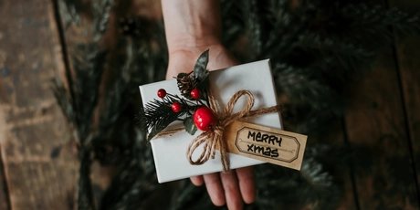 Hand with a wrapped Christmas gift 