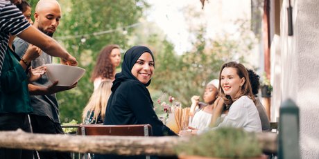 Portrait of young woman sitting with friends in balcony during party