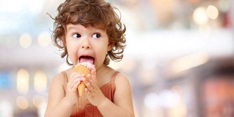 Kid eating ice cream. Funy curly child with icecream.