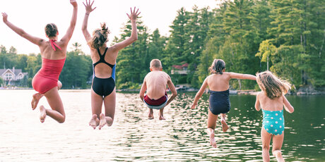 Children jumping into a lake