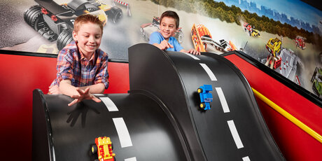 Jungs spielen mit Rennbahn im Legoland