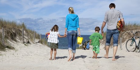 family walking towards the beach