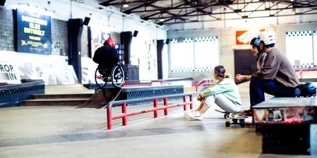 Skatehalle Berlin: Two skaters watch wheelchair skating