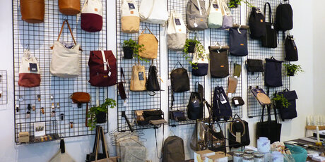 Second hand and vintage shop with bags on a grid on the wall 