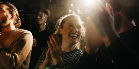 Lachende Frau applaudiert