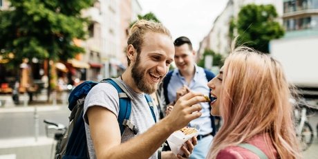 Young Couple Enjoy A Snack Together During A Bus Journey Rest Stop