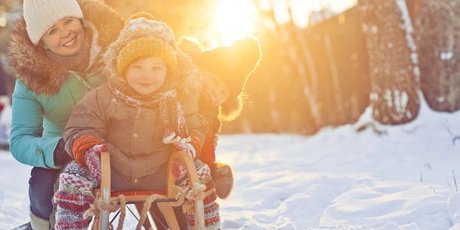 Mutter mit zwei Kindern auf einem Schlitten
