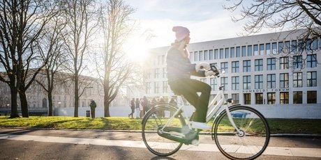 Radfahrerin vor dem Humboldtforum in Berlin im winterlichen Sonnenschein