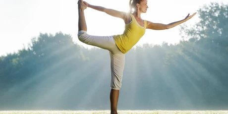 Frau praktiziert Yoga im Park