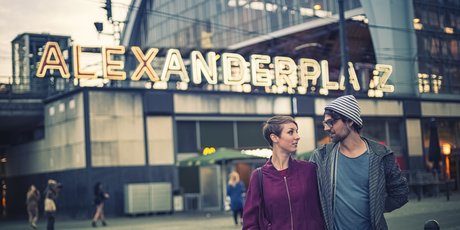 Young couple in front of the Alexanderplatz S-Bahn station at dusk