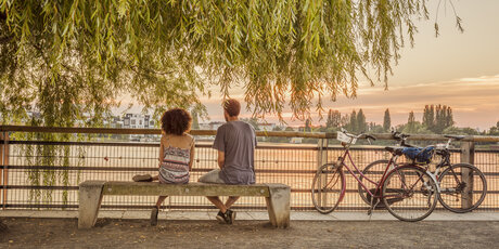 Romantic break of two cyclists at Lake Rummelsburg in Berlin