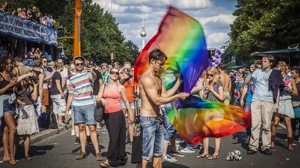Menschen mit Regenbogenfahne auf dem CSD in Berlin
