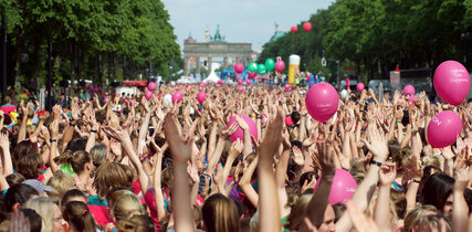 jubelnde Menschen bei Sportveranstaltung in Berlin Tiergarten mit Blick auf das Brandenburger Tor