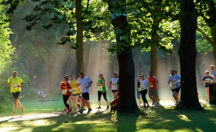 Group of people is running through the forest
