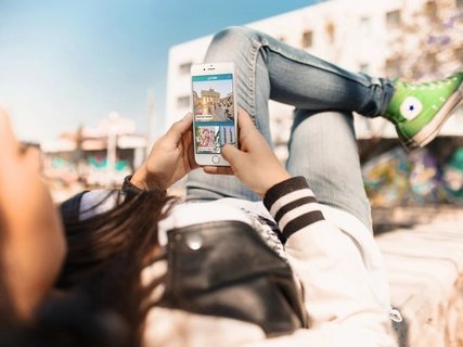 Young woman uses street art highlight of the ABOUT BERLIN app. Young woman uses street art highlight of the ABOUT BERLIN app.