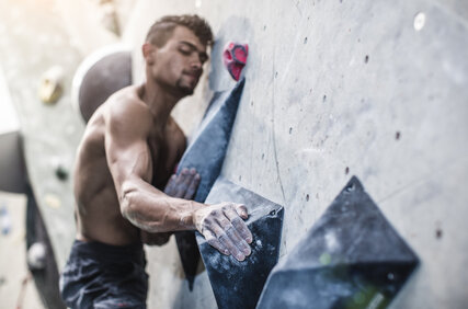 Athletischer Mann an einer Boulderwand