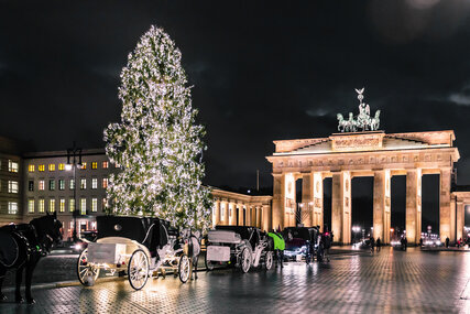 Christmas tree and carriages in front of the Brandenburg Gate in Berlin