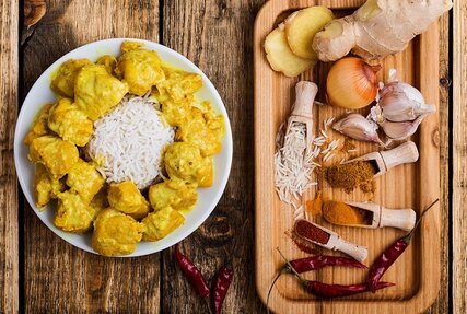 Chicken Curry mit Reis, Gewürzen wie Chili, Ingwer und Knoblauch