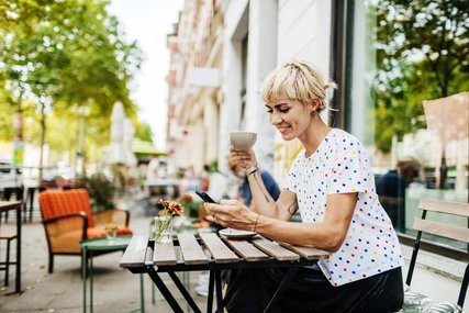 Frau sitzt im Straßencafé