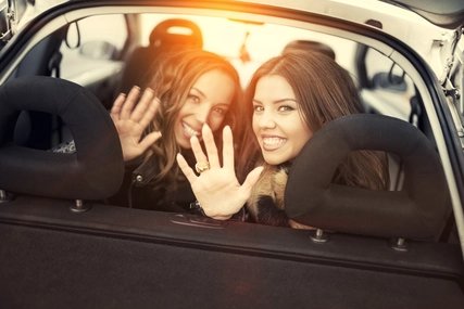 Winkende Frauen vom Rücksitz