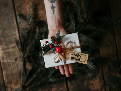 Hand with a wrapped Christmas gift 