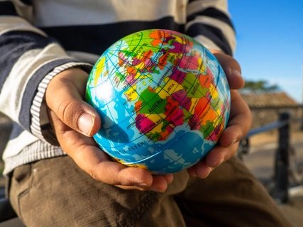 The hands of a child with a globe in his hands. Ecology and globalization concept