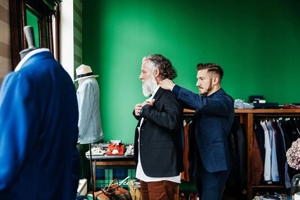 Verkäufer hilft Kunde im Herrenmode Geschäft