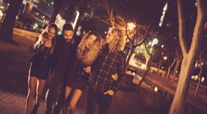 Berlin Nightlife Young adult enjoying the night walking and hugging joyfully each other