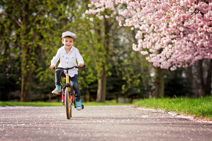 kleiner Junge mit Fahrrad im Frühling