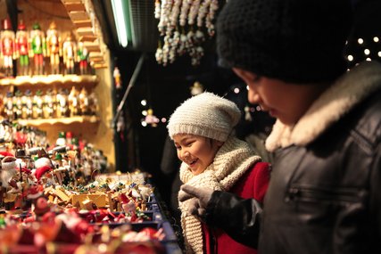 Boy and girl having fun buying christmas decoration at the christmas market