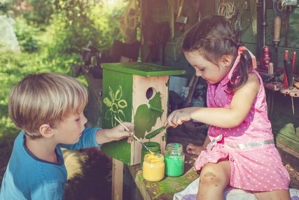 Kinder bemalen Vogelhäuschen