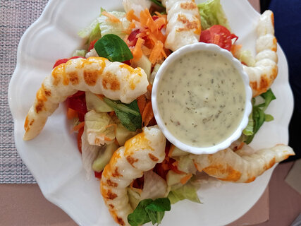 Kosher shrimp substitute with bearnaise sauce, on raw vegetable salad