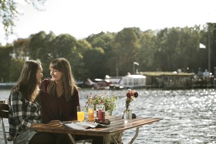 Zwei Frauen sitzen am Wasser in Berlin Pärchen im Treptower Park