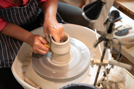 Frau Lüder bei der Herstellung einer Vase aus Keramik.