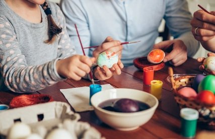 Familie beim Ostereier bemalen