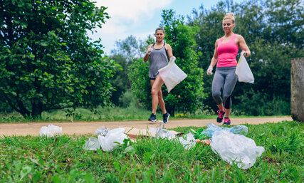 Waste pile and two girls doing plogging