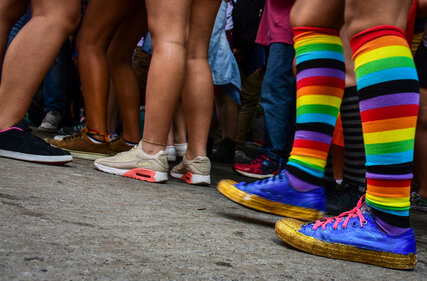 Person mit Regenbogensocken in Menschenmenge