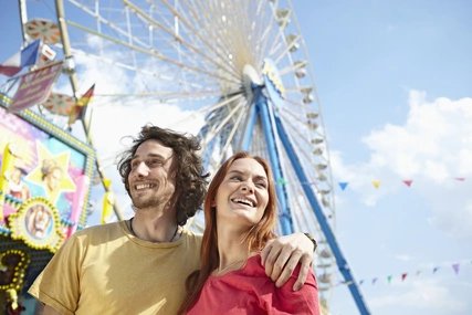 Rummel mit Riesenrad Junges Paar auf einem Rummelplatz