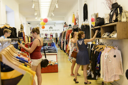 Women are shopping in a vintage and second hand clothing shop