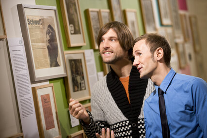 Zwei Männer schauen sich Bilder an im Schwulen Museum Berlin