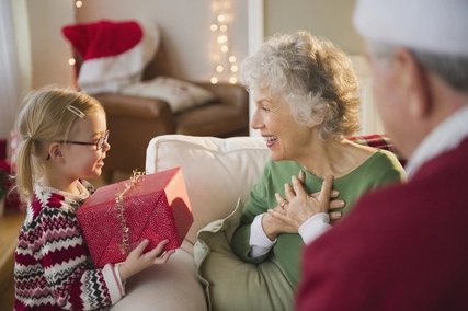 Granddaughter giving Christmas present to Grandma