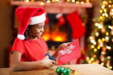 Beautiful girl making Christmas cards.