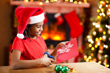 Beautiful girl making Christmas cards.