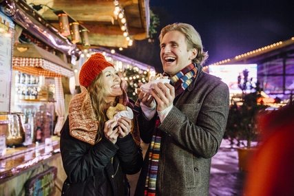 Enjoying Doughnuts From The Christmas Market