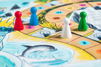 Close-up of a dice game with figures and colourful background 